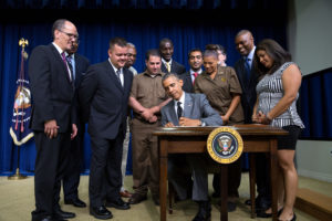 President Barack Obama signs the "Fair Pay and Safe Workplace" executive order in the Eisenhower Executive Office Building South Court Auditorium, July 31, 2014. The President is joined on stage by Labor Secretary Thomas Perez as well as employers who support fair labor practices, workers who have seen firsthand the effects of workplace violations, and advocates who have worked to improve fair pay and safety standards. (Official White House Photo by Pete Souza)